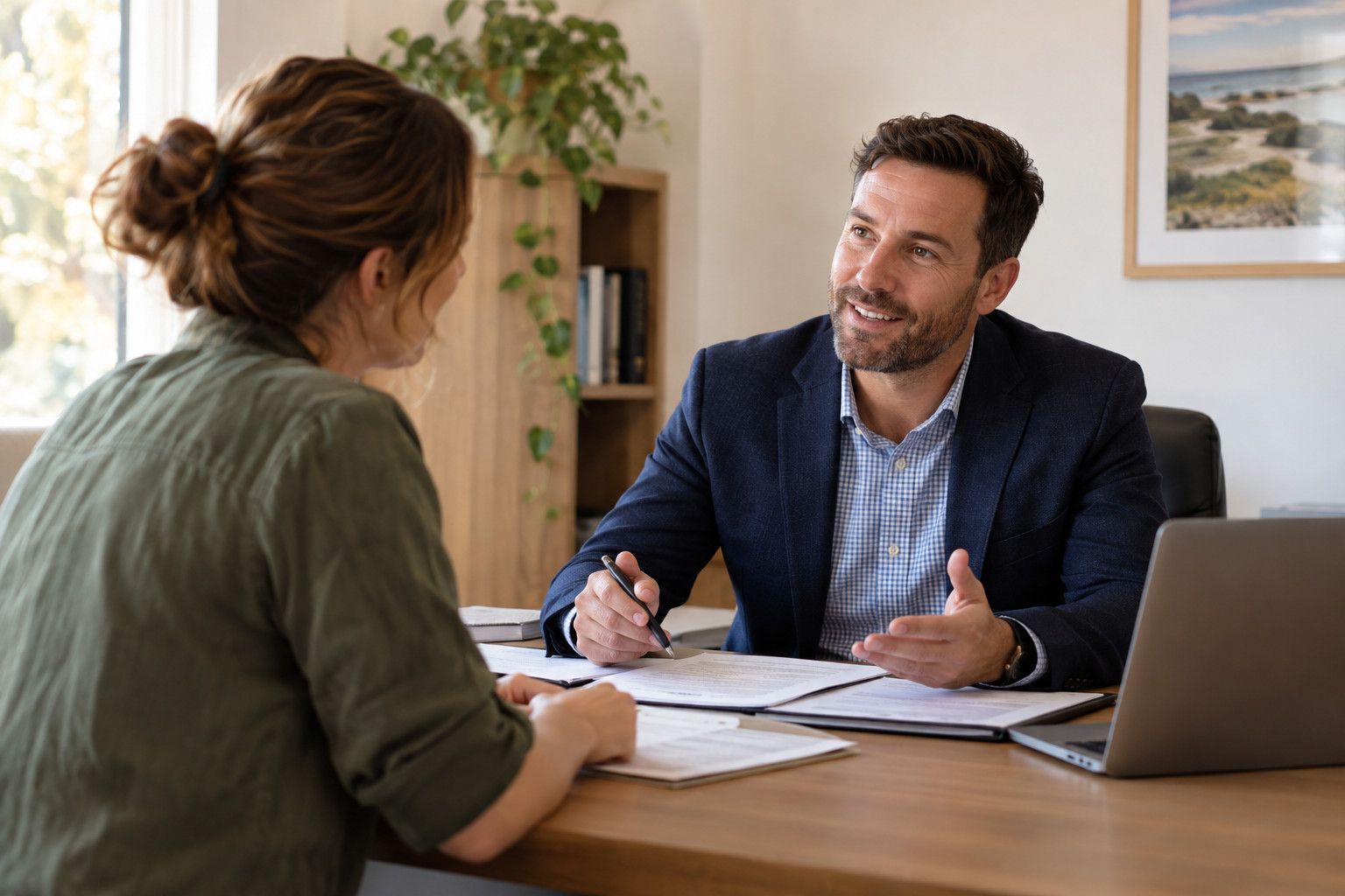 Insurance broker meeting a client at his desk